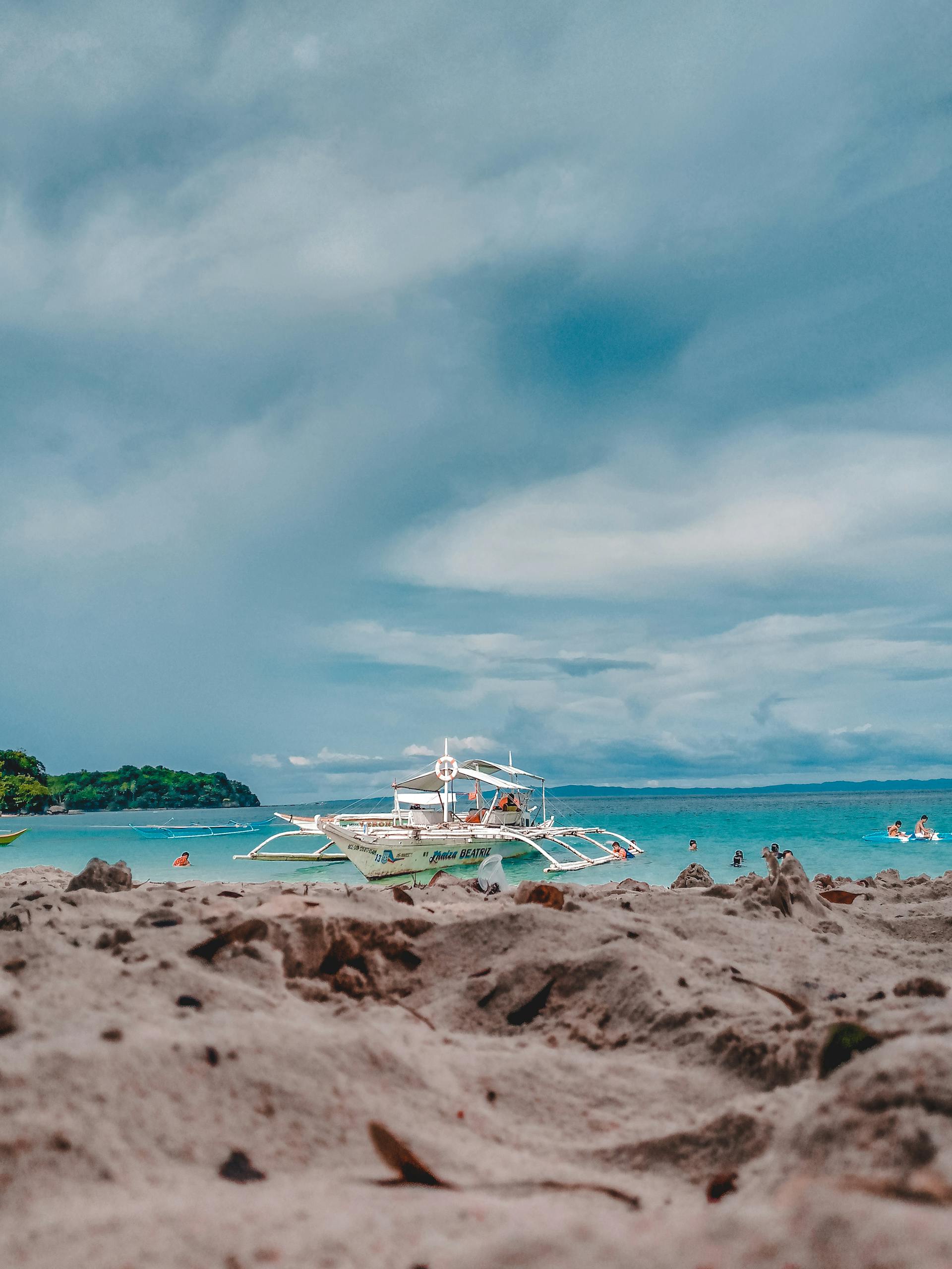 Scenic view of a traditional Filipino banca on a sunny beach in Sorsogon City, Philippines.